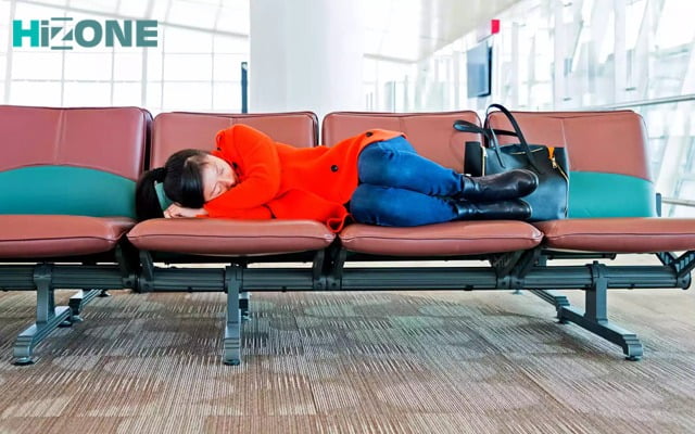 یک زن خوابیده روی نیمکت فرودگاه 